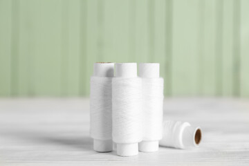 Thread spools on white wooden table