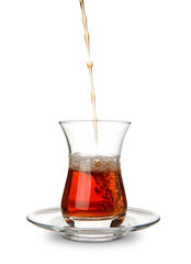 Pouring of Turkish tea into glass on white background