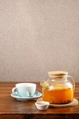 Glass teapot with fruit tea over empty wall. Copy space, place for text