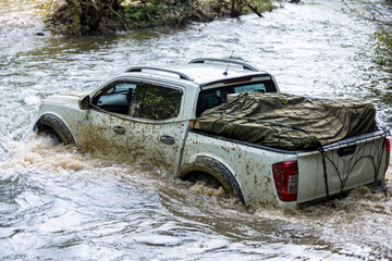 Pick-up truck is off roading in  the river in the Forest . Car 4x4, Drive to cross the river, In...