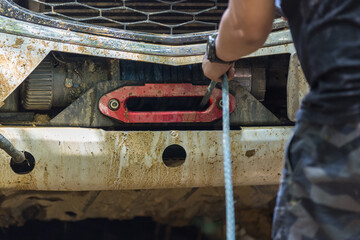 Man use Winch Device at Front of Pick up Off Road Vehicle. Man use the winch helps to drag the car...