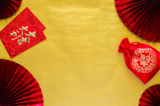 Chinese new year background concept with red envelope packets or ang bao (word mean auspice) and red bag (word mean wealth) on gold empty space background with red fans.