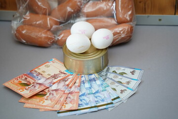 Almaty, Kazakhstan - 10.04.2022 : Various food products and banknotes of Kazakhstani tenge are laid out on the table.