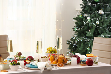 Christmas table setting with glasses of champagne and tasty chicken in dining room