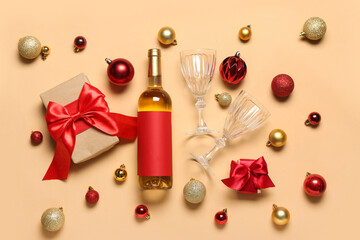Bottle of wine with glasses, Christmas balls and gifts on beige background