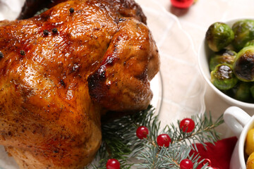 Plate with tasty chicken and Christmas branches on beige tile background, closeup