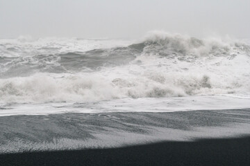 High waves breaking on coast monochrome landscape photo. Beautiful nature scenery photography with mist on background. Idyllic scene. High quality picture for wallpaper, travel blog, magazine, article