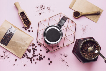 Composition with geyser coffee maker, grinder and beans on pink background