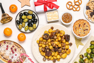 Christmas table setting with tasty food and decor on white wooden background