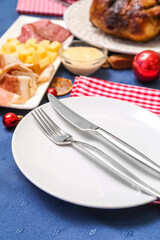 Christmas table setting on blue cloth, closeup