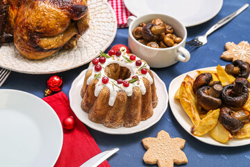 Christmas table setting with tasty food on blue cloth, closeup