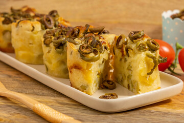 Savoury olive and cheese muffins on ceramic plate.