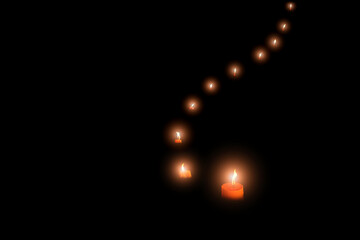 Isolated image of burning candles in a row on black background