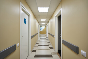 corridor with open and closed doors with numbers on it. hospital corridor with wards