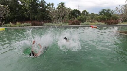 Group of diverse friend jumping into the pool, having a party together