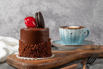 Chocolate and strawberry cake on a dark background. Biscuit prepared with special cream, chocolate and fruit cake with coffee. Bakery products