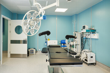 operating room with large operating light, resuscitation equipment and patient monitoring.
