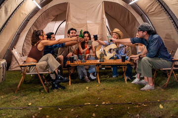 Group of diverse friend having outdoors camping party together in tent.