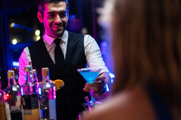 Caucasian profession bartender making a cocktail for customer at a bar. 