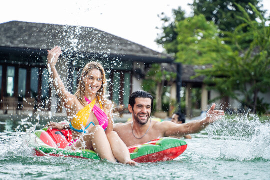 Caucasian young couple spend free time having a pool party together. 