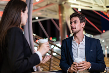 Caucasian young businessman and woman stand outdoor in city at night. 