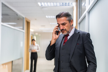 Caucasian businessman talk on phone and walking in corridor of office. 