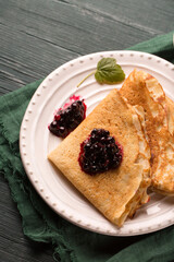 Thin ruddy pancakes on a wooden table