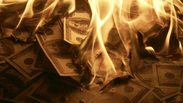 Dollar bills are burning, closeup. Dollar is burning with bright flame. Concept of ruin and crisis