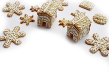 Small Gingerbread houses with many gingerbread cookies in shape of stars and snowflake isolated on white background with copy space