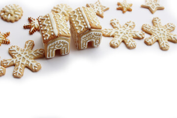 Small Gingerbread houses with many gingerbread cookies in shape of stars and snowflake isolated on white background with copy space