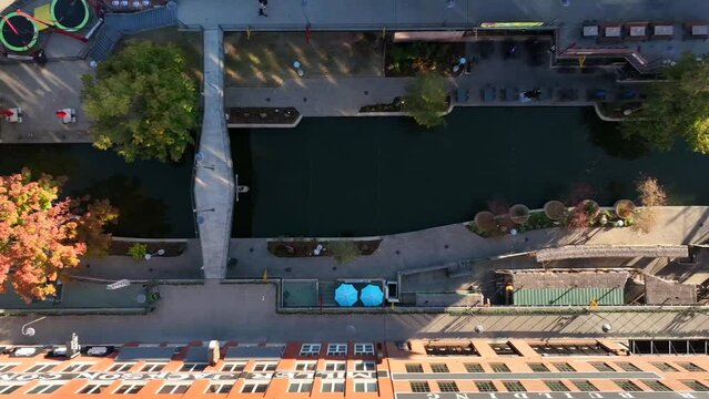 Top down aerial of riverwalk canal in USA. Bridge road over waterway.