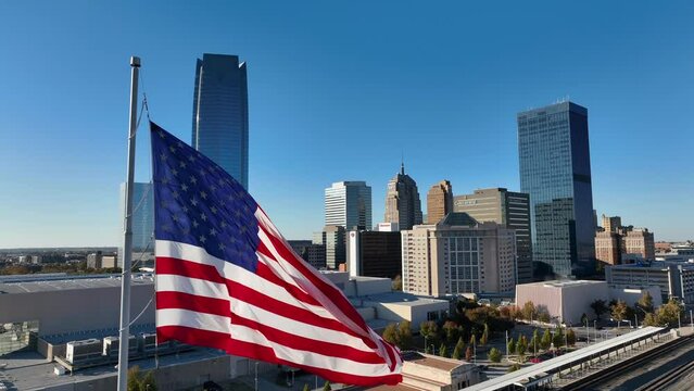 American flag with OKC skyline. Oklahoma City urban downtown center with Devon Energy Center and skyscrapers.