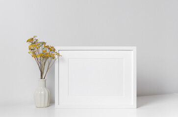 Landscape frame mockup in white minimalistic interior with dry flowers in vase