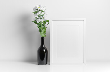 White frame mockup wih flowers in vase decorations, blank mockup template with copy space