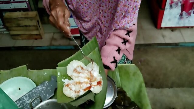 a seller of traditional Javanese food called lupis in a traditional market