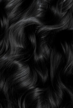 Brunette or black hair. Female long dark hair in black. Beautifully laid curls. Closeup texture in a dark key. Hairdressing, hair care and coloring. Shading gray hair. Background with copy space.