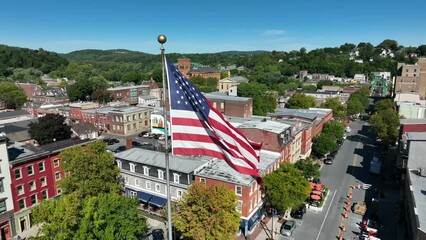 USA flag in small town America. Sunny day with historic buildings in Easton Pennsylvania. Aerial orbit.