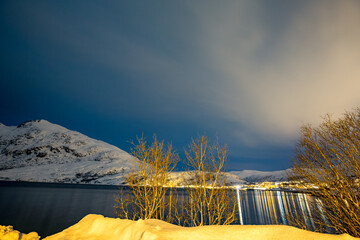 Night long exposure with water reflections near a fjord close to Tromsø, Northern Norway....