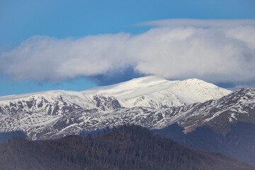 Mountains covered with snow. The clouds embrace the white mountains.