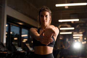 Fototapeta na wymiar Sporty woman stretching arm before gym workout.