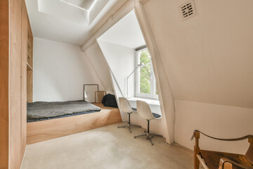 a bedroom with a bed, desk and chair in the corner of an attic style room that has been used for...