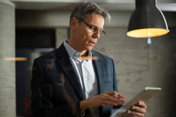 Portrait of successful businessman in office. Man writing on the glass board in office..