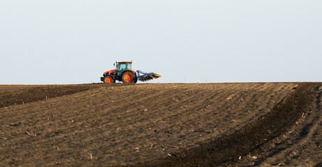 Obraz premium Tractor preparing land with seedbed cultivator.