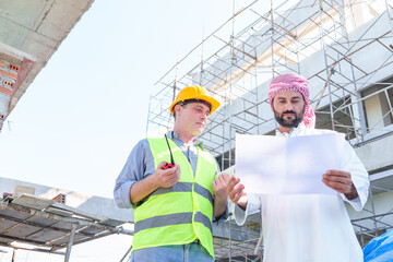 Arabic businessman teammates working together, construction engineer architect and worker looking building model and blueprint blueprint plans of Arab businessman.