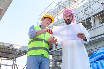 Arabic businessman teammates working together, construction engineer architect and worker looking building model and blueprint blueprint plans of Arab businessman.