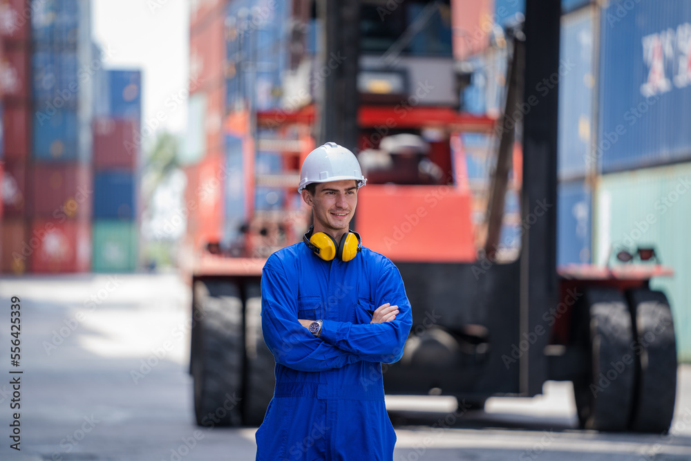Poster Engineer doing stock tick check and overseeing the transportation of cargo with containers inside the warehouse.