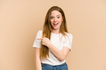 Young redhead woman cut out isolated pointing to the side