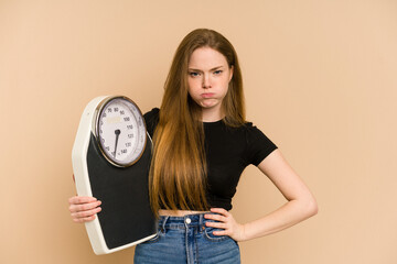 Young redhead woman holding a scale isolated cut out
