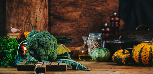 Food background with organic farm broccoli cabbage, pumpkins, herbs and spices on rustic wood...