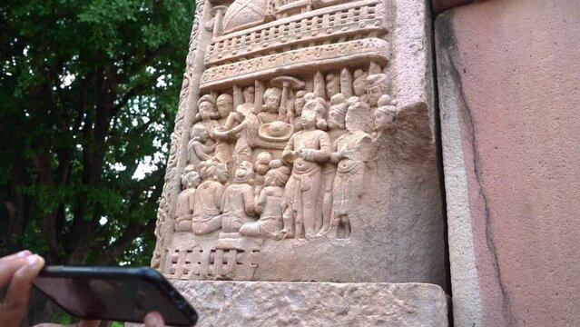 A Woman With Smart Phone Capturing The Pillar Carving At The Great Stupa In Sanchi, Madhya Pradesh, India. Zoom Out